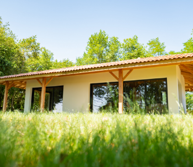 Maison ossature bois avec pergola apparente en terrain boisé